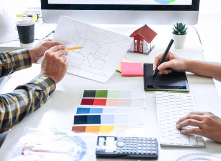 Team design of young Interior graphic designer working house project sketching on graphic tablet and...