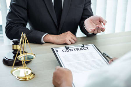 Male lawyer or counselor discussing negotiation legal case with client meeting with document...