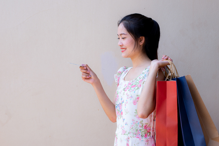 Portrait of beautiful girl holding shopping bag and credit cardの写真素材