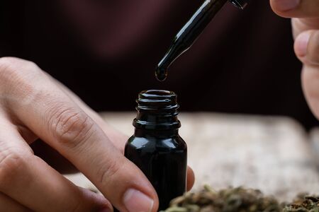 Canabis oil pouring from a glass bottleの写真素材