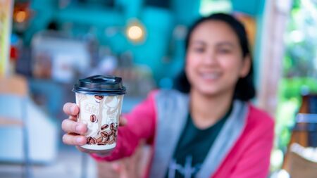 Beautiful girl giving coffee cupの写真素材