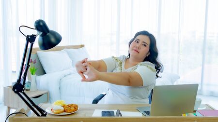 Fat woman exercise in the workplaceの写真素材