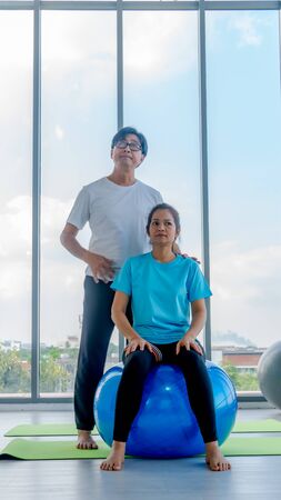 Old man and woman playing yogaの写真素材