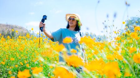 Beautiful women blogging in the flowers gardenの写真素材