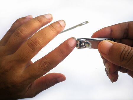 Man's hands with dirty nail using nail clipper for fingernails manicure isolated on white background