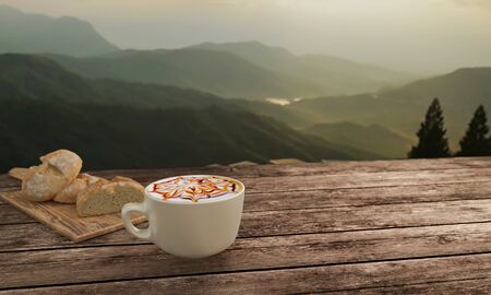 latte art coffee with chocolate sauce and caramel sauce  on Milk foam in white cup. Blur home made bread and  butcher in breakfast  concept on wooden table. Background mountian view and sunrise. 3D rendering.の写真素材