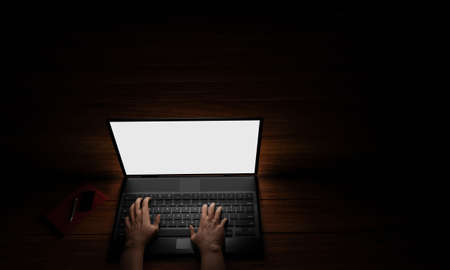 The hand of a person using a notebook or laptop, a blank screen, white, dark background, blacklight shines down on the hand. Mystery operation or hacker.3D Renderingの写真素材
