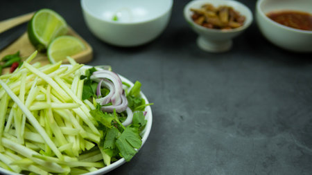 Yum, mango photo top views Food arrangement. Spicy salad food, topped with fried nuts and crispy...
