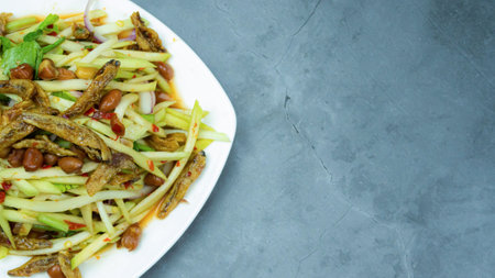 Yum, mango photo top views Food arrangement. Spicy salad food, topped with fried nuts and crispy fish. The main ingredients are raw mango, lime juice, fresh chili powder, fish sauce, sugar to mix.の写真素材