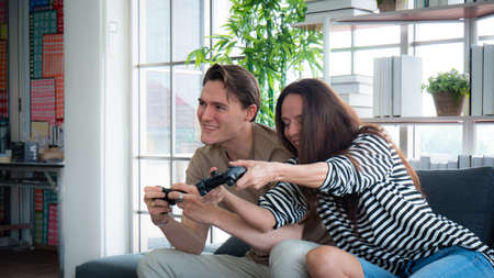 Concept, game or e-sport. Couple teasing while playing games happily Two people looking at a...