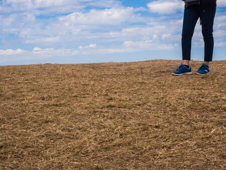 young woman stand on mountain,blue sky background,stand alone on grass