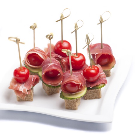 Canapes with tomato and bacon on a plateの写真素材
