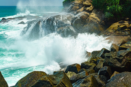 Big waves and lots of splashes with foam on the rocky shoreの写真素材