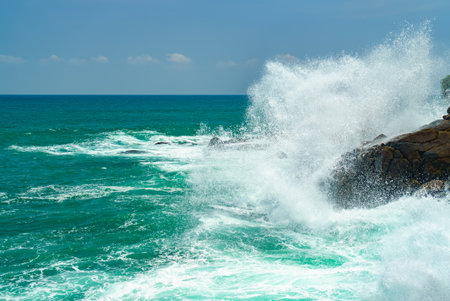 Splashes of waves crashing against the rocksの写真素材