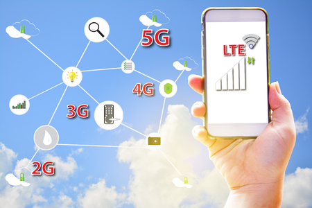 Hand holding smartphone using LTE technology hispeed internet for control life style with...