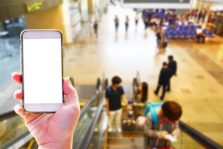 People hand use cellphone at the hall airport background with copy space on screen for using mobile app about activities in the airport or checking flight planの写真素材
