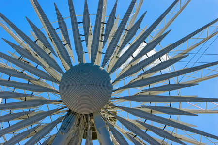 Hub and spokes of a ferris wheel against a bright blue skyの写真素材