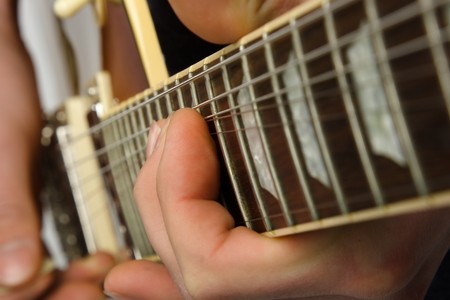 Close up of an electric guitar being played.