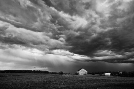 Landscape image of a summer storm over a farm field in B&W.の写真素材
