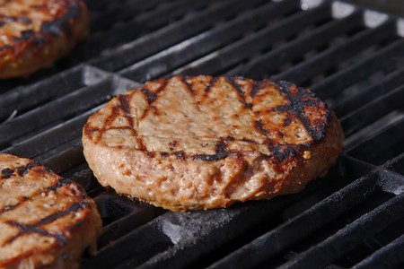 Juicy burger grilling on a hot barbeque.の写真素材
