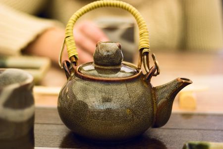 Teapot with wicker handle in the Japanese restaurant. Close-Upの写真素材