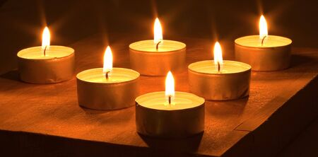 Many lighted candles on a dark background.の写真素材