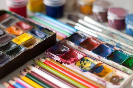 Items for drawing and art: watercolor paint, brushes, colored pencils.の写真素材