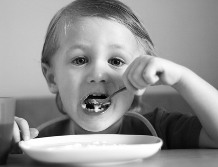 A little boy eats. B & W photo.の写真素材