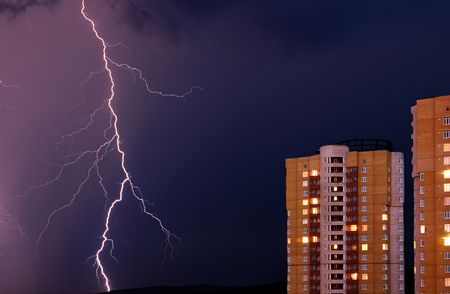 Thunderstorm in the city. The flash of lightning against a background of dark and gloomy sky in the...