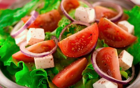 Greek salad with tomatoes cheese, herbs and onionsの写真素材