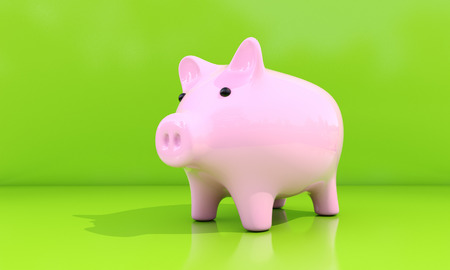 Shiny pink piggy bank on a green backgroundの写真素材