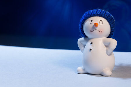 Cheerful snowman on a blue snowy background.の写真素材