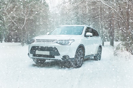 The modern SUV on a background of a winter forest. Offroad car on the snowの写真素材