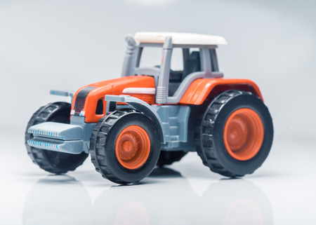 Small red toy tractor on light background, shallow depth of fieldの写真素材
