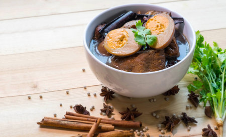 Stewed eggs or eggs in brown sauce with spices by Thai food, On the table wood, Natural lightの写真素材