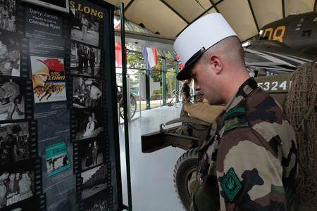 France, Normandy, June 6, 2011 - The Legionnaire of the French foreign legion is studying the document in the museum of the military operation in 1944 during the landing of the Allies in Normandy.のeditorial素材