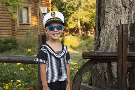 Boy child in captains clothes smiles tenderlyの写真素材