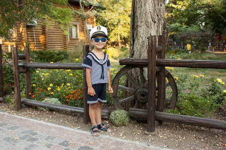 Boy child in captains clothes smiles tenderlyの写真素材