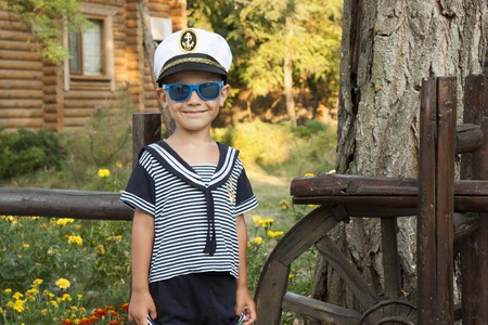 Boy child in captains clothes smiles tenderlyの写真素材