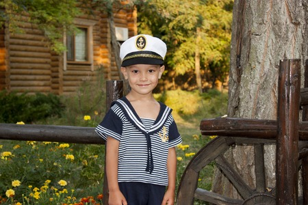 Boy child in captains clothes smiles tenderlyの写真素材