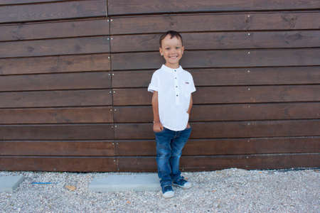 Handsome 4 year old boy smiling on a blackboard backgroundの写真素材