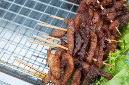 Close up Fried Pork stick on grid  market, Thai cuisine traditional signature street food, quick delicious and easy eating, write copy spaceの写真素材