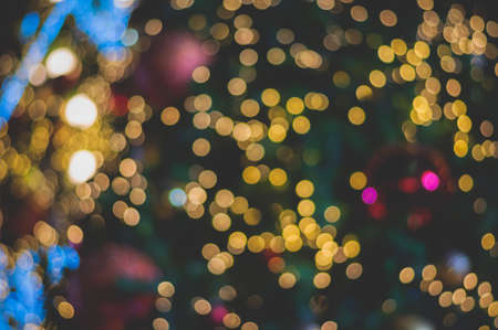 Blurred glitter ball celebrate christmas tree with illumination bulb light background, soft color cinematic vignette toneの写真素材