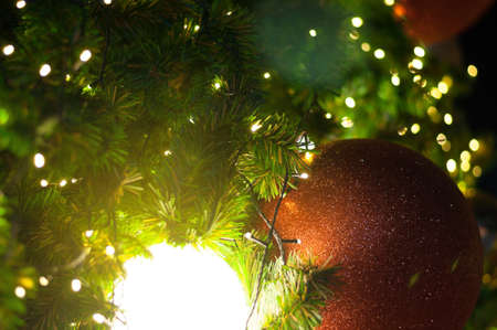 Close up big red glitter ball christmas on tree with wire white light background