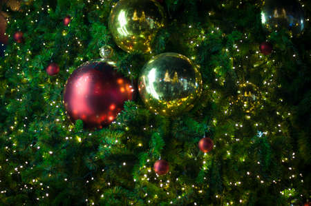 Close up big red glitter ball christmas on tree with wire white light backgroundの写真素材
