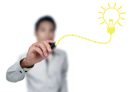 Hand with a pen drawing light bulb.の写真素材