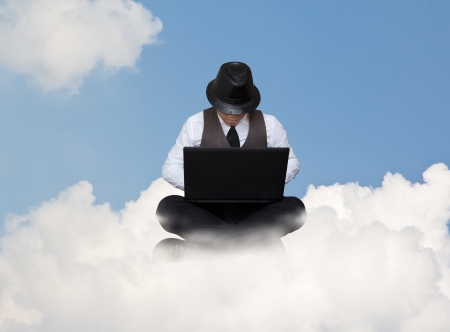 Businessman working with laptop on a cloud.の写真素材
