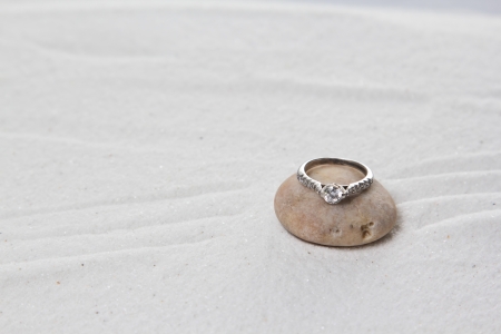 Wedding ring on white sand.
