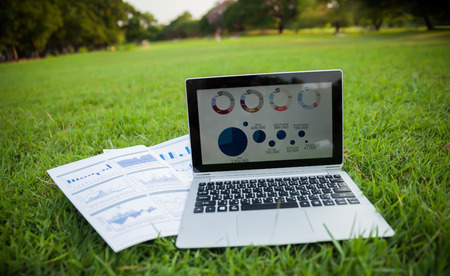 Reported profits on the paper and laptop in the garden.の写真素材