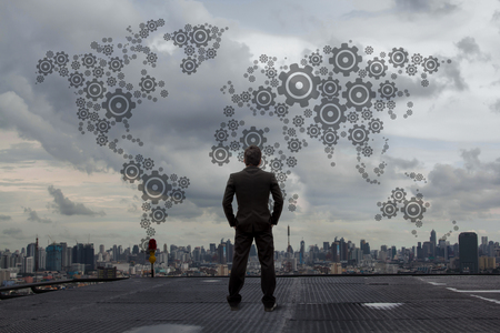 Businessman looking gears that drive the economy.の写真素材